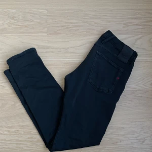 Svarta Replay Anbass jeans  - Säljer ett par svarta Replay Anbass jeans i storlek 31/32. Sitter riktigt snyggt och är i väldigt bra skick – inga hål eller fläckar. Har en snygg röd “R”-detalj på bakfickan också.