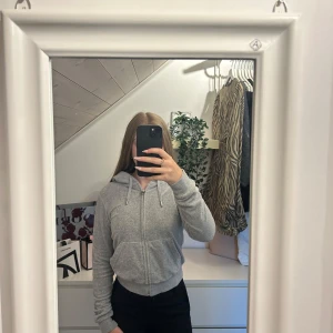 Grå hoodie med dragkedja - Säljer en enkel och stilren grå hoodie med dragkedja och huva. Tröjan har snörning i huvan, ribbade muddar och fickor framtill. Säljer då den för för liten och inte kommer till användning. Den är från juicy couture och är äkta.