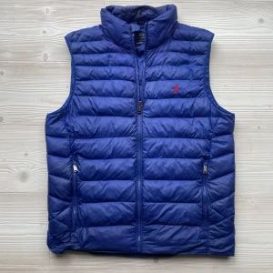 Ralph lauren väst  - ||Stilren dunväst från Ralph lauren i en väldigt exklusiv och unik blå färg||Västen har broderat Ralph lauren märke på bröstet, och justerbar storlek vid midjan||Toppskick! Inga tecken på användning||Denna färgvarianten tillverkas och säljs inte längre, detta är den ända på den begagnade marknaden||Storlek S kan passa någon som bär M också||Nypris 3599:- mitt pris 1529:-||Priset är inte hugget i sten och kan sänkas vid en snabb och smidig affär||vid frågor är det bara att höra av sig!||