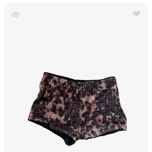 Leopardmönstrade paljettshorts - Snygga shorts med leopardmönster och glittriga paljetter i bruna och svarta toner. Modellen är tight och lowaist.
