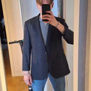 Elegant Hugo Boss-kavaj – BOSS SELECTION - Elegant Hugo Boss-kavaj – BOSS SELECTION Säljer en stilren mörkare jeans-blå kavaj från Hugo Boss (BOSS Selection-linjen). Klassisk passform, snygg struktur och kvalitetskänsla rakt igenom. Perfekt för både vardagligt snygg stil eller mer uppklädda tillfällen. Storlek: M men har anurlunda passform (se bilder för passform) Bra skick!  Pris=1095                                                                              Pris kan diskuteras vid snabb affär!!