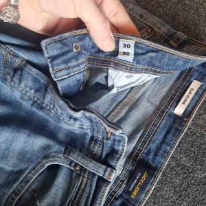 Blå slim jeans från Jack & Jones - Säljer ett par klassiska blå slim fit jeans från Jack & Jones. Jeansen har normal midja, fem fickor och stängs med dragkedja och knapp. Perfekta för dig som gillar en smalare passform och tidlös denimstil. Stl 30-32  PRIS:200KR