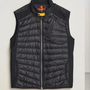 Mörkblå dunväst från Parajumpers L  Nyskick - Snygg dunväst från Parajumpers i nyskick, quiltad framsida och dragkedja. Västen har en bröstficka med dragkedja och klassisk gul detalj vid halsen. Perfekt för lager-på-lager och stilren look. Säljs för 1300 kr 18/5 22:00, bud på +1399 minimum, sista chansen att fynda.