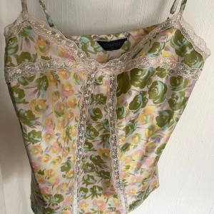 Blommig linnetopp med spets från Alwear - Säljer en söt linnetopp från Alwear med grönt, rosa och gult blommönster. Strl 10/38/M Aldrig använd