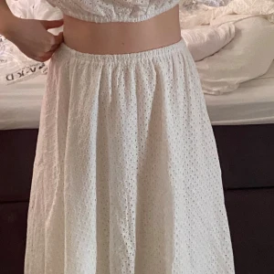 Vit långkjol NAKD - Vit långkjol i broderad bomull med elastisk midja. Kjolen har ett romantiskt hålmönster och faller fint ner till anklarna. Strl 36