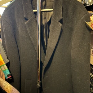 Svart rock från Jack & Jones - Klassisk svart rock från Jack & Jones med snygg krage och två fickor framtill. Perfekt för vår/sommar/höst dagar och ger en stilren look. Fodrad insida för extra komfort.