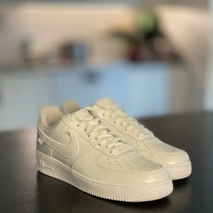 Nike Air Force 1 x Louis Vuitton vita sneakers - All new (NO BOX) Exklusiva vita Nike Air Force 1 sneakers i samarbete med Louis Vuitton. Skorna har präglat LV-mönster över hela ovandelen, klassisk snörning och rund tå. Snygg kombination av street och lyx med tydliga loggor från båda märkena.