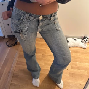 Ljusblå bootcut jeans - Säljer ett par ljusblå bootcut jeans, de har fina detaljer som glittrar. Står ingen storlek men skulle gissa på xs-s jag brukar ha s i jeans och de passar mig. Jag är ca 162.