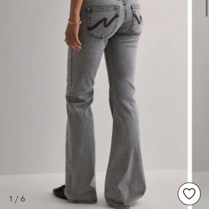 Grå bootcut jeans med dubbla knappar - Snygga grå jeans med bootcut passform och markerade sömmar. Byxorna har dubbla knappar i midjan och klassiska fickor både fram och bak. Perfekta för dig som gillar en retroinspirerad look. Dom är från Nelly använda 2 gånger, köpts för 699