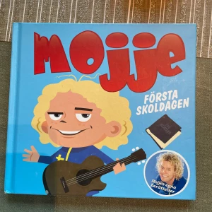 Mojje: Första skoldagen - En färgglad barnbok om Mojje, en kille med lockigt hår och gitarr, som ska börja skolan. Boken är illustrerad med humoristiska bilder och handlar om Mojjes första skoldag fylld av knasiga och pinsamma händelser. Perfekt för yngre barn som ska börja skolan.