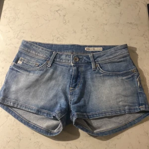 Blå jeansshorts  - Snygga blå jeansshorts från G-Star som är låg midja! Super fina där bak iallafall när dom sitter på.