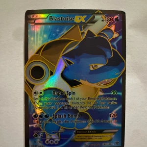 Blastoise EX (142 Full Art) Pokémonkort - Säljer ett Blastoise EX full art-kort från XY Base Set, nummer 142/146. Kortet är holografiskt. Ultra Rare-kort med attacker som Rapid Spin och Splash Bomb. Perfekt för samlare eller Pokémon-fans. Kortet är värderat till 65 dollar vilket motsvarar ungefär 630kr. 