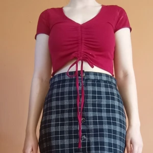 Röd topp - Vinröd croppad topp med korta ärmar och snygg knytdetalj framtill. V-ringad och man kan dra åt banden efter hur man själv vill ha dem. Köpt på Sellpy men ursprungligen från Shein. Storlek S