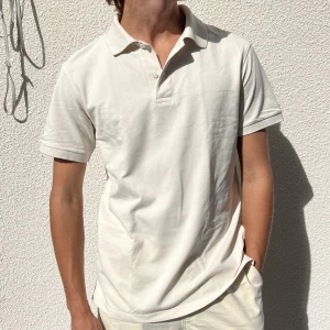 Pikétröja - Vit pikétröja från UNIQLO. Knappt använd, inga defekter. Jättefin och perfekt att ha som den är, eller under en tröja. Storlek M. Kontakta mig vid frågor eller om fler bilder önskas!