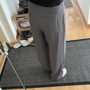 Gråa kostymbyxor  - Supersköna gråa kostymbyxor från NA-KD 🐭uppsydda i benen och passar mig som är 160 cm lång. Invikta i midjan på bilden. Köpare står för fraktkostnad ❣️