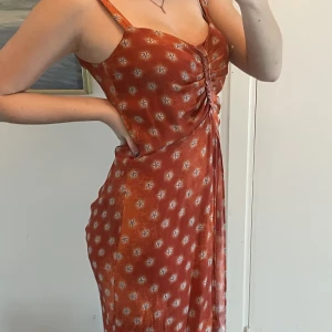 Klänning - Orange klänning som sitter jättebra på kroppen, tyvärr inte min färg. 100% viskos och jätteskön. Har även ihopdragningar vid rumpan. Storlek S.