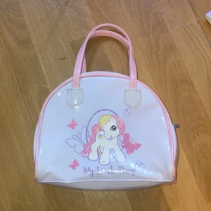 My little pony handväska - En barnväska med tryck. Ok skick, ren. Liten skada i baksida kant och lite slitna handtag. 