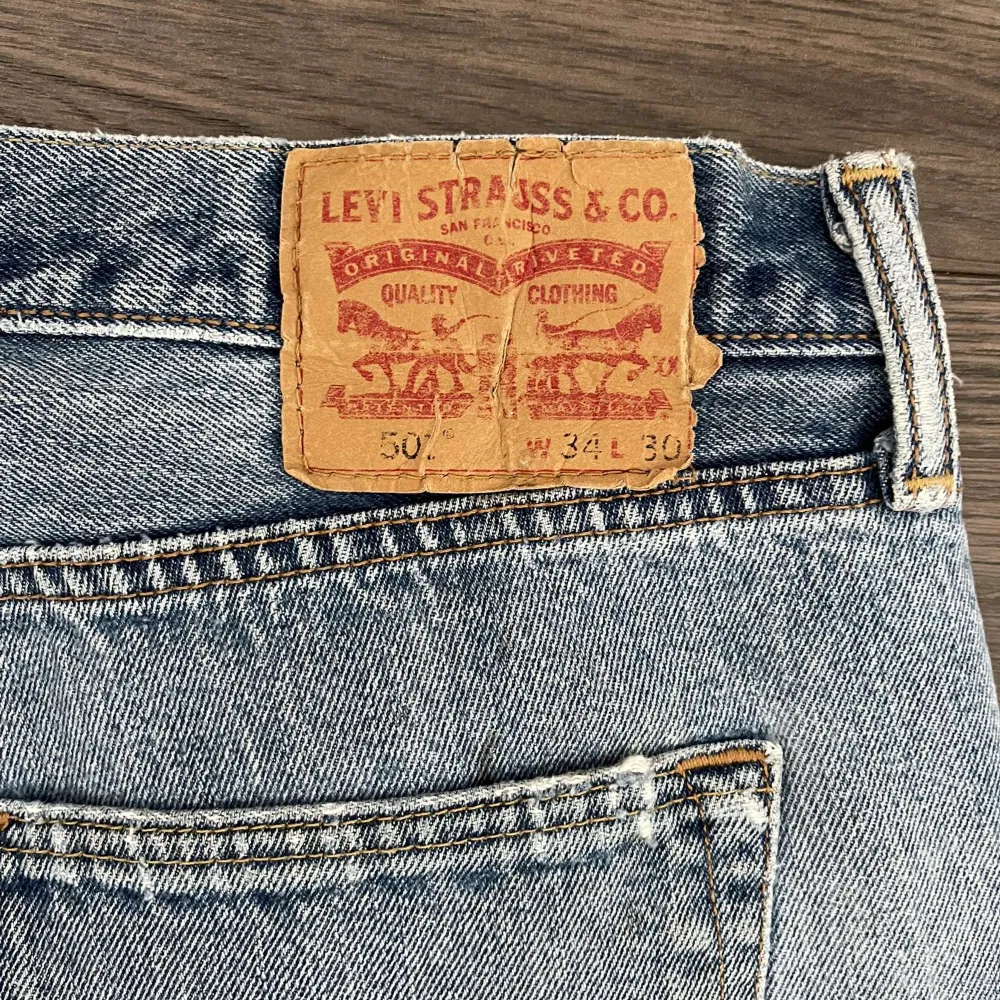 Jättefina Levi’s 501 i mörk tvättad färg, slitningar på knäna och storlek W34L30. Jeans & Byxor.