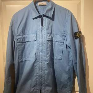 En riktigt schön stone island overshirt säljes nu, skicket är riktigt shysst 9,5/10. Overshirten är i storlek S. Hit me up i meddelande för funderingar kring denna skönhet. 