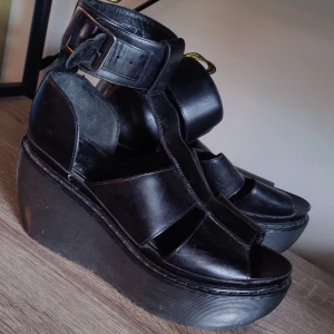 Dr Martens platåsandaler - Ett par platåsandaler från dr. Martens. Har ändast använts ett fåtal gånger och inte ingådda. I behov av vaxning men annars i fint skick. Platån är ca 10cm.