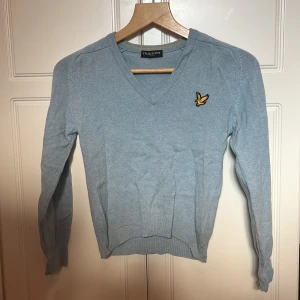Lyle & Scott tröja - V-ringad tröja från Lyle & Scott i blått. Gott skick