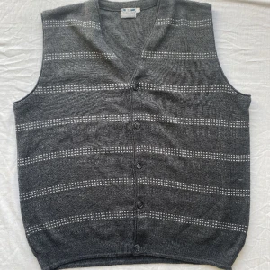 Randig väst  - En grå randig farfarfsväst med grå knappar. Mönstret fortsätter inte på baksidan. 