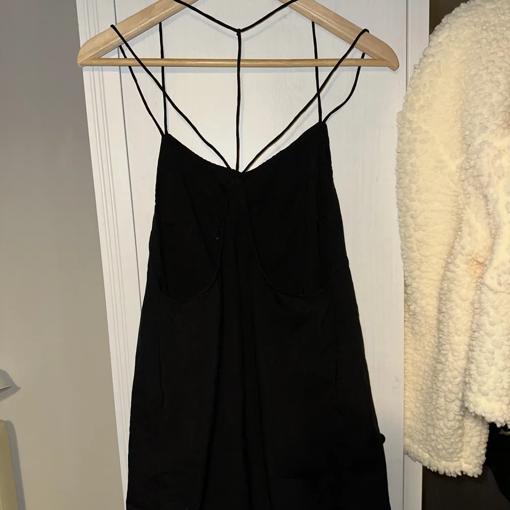 Polyblend dress with strappy detailing all over the shoulders and the back. Straight hem. Polyester blend. Moderately used great condition. Smoke and pet free storage space. Will gladly take more pics. Disclaimer: Please expect some general wear in all se. Toppar.