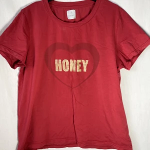 Röd t-shirt - Röd t-shirt med guldtryck. Längd: 41cm   Skicka DM vid frågor. ☆．。･