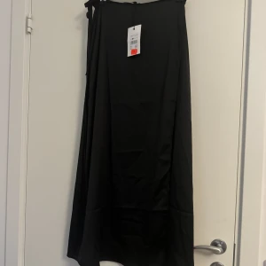 Satinkjol - En helt ny satinkjol från Bikbok i storlek S. Slits i sidan. Snörning i midjan 