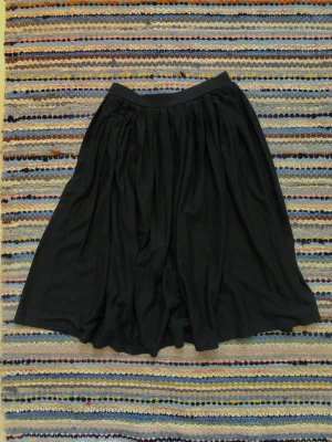 Räfflad Svart kjol - Plisserad svart midi kjol i storlek 36.