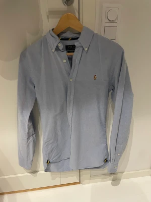 Ralph lauren skjorta - Säljer en snygg ralph lauren skjorta, färgen ljusblå och materialet är linne! Om du undrar nåt så fråga då mig!