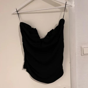 Party topp  - Svart tubbtopp med en fin v-ringning med metallbygel i ett slinkigt material  Använts 1-2 gånger innan 