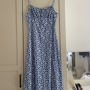 Blommig klänning  - Säljer denna blå/vita blommiga klänning. Har en slits framtill, aldrig använd.🤍