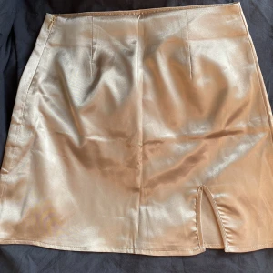 Satinkjol beige/champagne - Säljer denna jättefina beiga/champagne satinkjol med en slits på höger ben, från shein. Lite skrynklig men bara att strykas! 