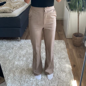 Beiga/bruna kostymbyxor - Beiga/bruna kostymbyxor i storlek 34/xs från bikbok. Byxorna är högmidjade.