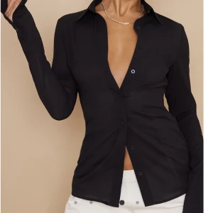 Svart mesh skjorta - HELT OANVÄND! Svart blus från prettylittlething i mesh-material så den är lite genomskinlig, men inte för mycket. Sitter otroligt bra och figurnära, säljer endast för att den är lite för liten på mig. Köp för 250:-