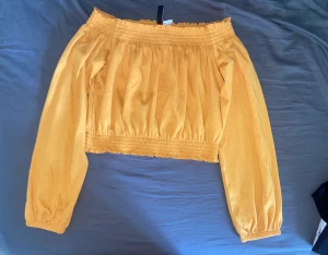 Off-shoulder topp - Snygg off-shoulder topp som passar perfekt till sommaren, säljs då den tyvärr inte kommer till användning  Använd ett fåtal gånger och är därför i bra skick Skriv gärna om ni har frågor eller vill ha fler bilder