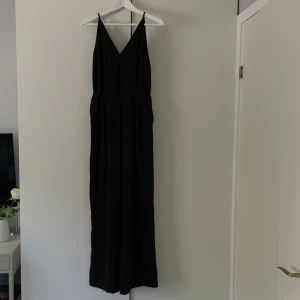 Byxdress med fickor  - Byxdress med fickor med resår i midjan. Finns även öglor för skärp. 