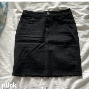 Svart jeanskjol - Svart jeanskjol med fransar nedtill Stolek s