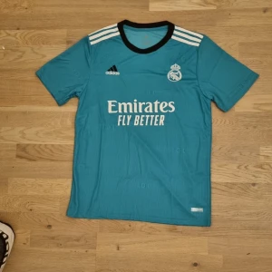 Real Madrid fotbollströja turkos - Säljer en riktigt clean Real Madrid tröja.⚪️ Inget namn på ryggen. Turkosblå. 