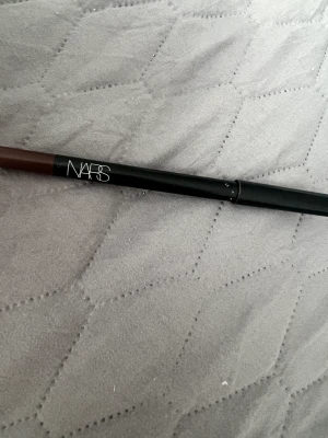 NARS High-Pigment Longwear Eyeliner i färgen/ shade Mambo  - Den populära och virala NARS High-Pigment Longwear Eyeliner i färgen/ shade Mambo - sotig brun färg. Eyelinern håller bäst av alla andra på marknaden. Inköptes för 320 kr och har använts enbart ca 3 gånger.   Sökord: eyeliner, gelé , smink, gele , makeup,