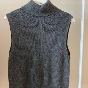 Stickad väst med krage - Säljer denna för den inte längre kommer till användning! Skulle säga den är mellan grå färg och svart! Fråga för fler bilder!