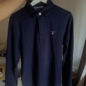 Gant piké tröja - Säljer denna gant tröja i modellen original heavy rugger i färgen midnight blue. Normal passform. Säljes pågrund av ingen användning. Jätte fint skick. Köparen står för frakten! Nypris 800-999kr.