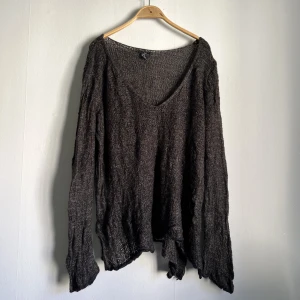 Stickad tröja - Luftig stickad tröja i brun med svart kant långt ner. I gott men använt skick, inte trasig någonstans.