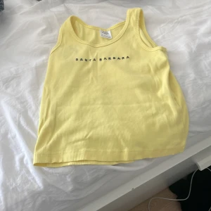 Zara - Det är ett gult linne som har en svart text som säger santa Barbara.