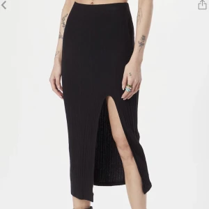 Kjol - Säljer denna svarta kjolen med en slits från Gina Tricot i modellen Adela Petite. Väldigt sparsamt använd