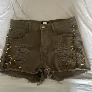 Slitna militärgröna shorts med guldiga nitar. Använt men bra skick.