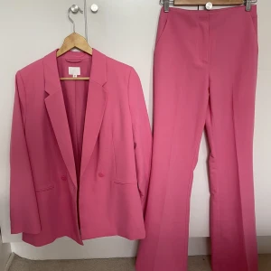 H&M Rosa kostym  - Säljer denna jätte fina kavajen i S och kostymbyxorna i 34. Aldrig använd, finns prislapp kvar på kostymbyxorna. Köp båda för 400kr annars kavajen för 250kr och kostymbyxorna för 200kr. Nypris: kavajen 500kr och kostymbyxorna 300kr.❤️ Pris kan diskuteras!