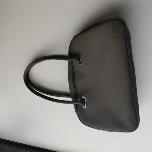 Lacosteväska - Fint skick utsida, tyvärr några fläckar på insidan.