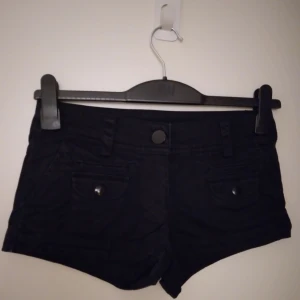 Svarta korta  shorts, Strlk 34 /  XS. Flera fickor. Stängs med dragkedja och knapp. Material: Kraftigare bomullstyg. - Svarta korta shorts, Strlk 34 /  XS. Flera fickor. Stängs med dragkedja och knapp. Material: Kraftigare bomullstyg. Felfria. Säljer även vita och korallfärgade av samma modell, strlk 32 och 36 - se mina övriga annonser.